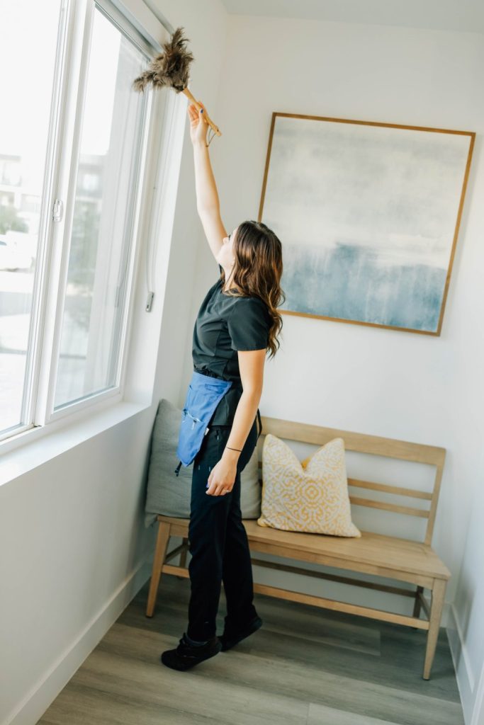 Cleaner dusting window in a Washington Fields home during fall allergy season.