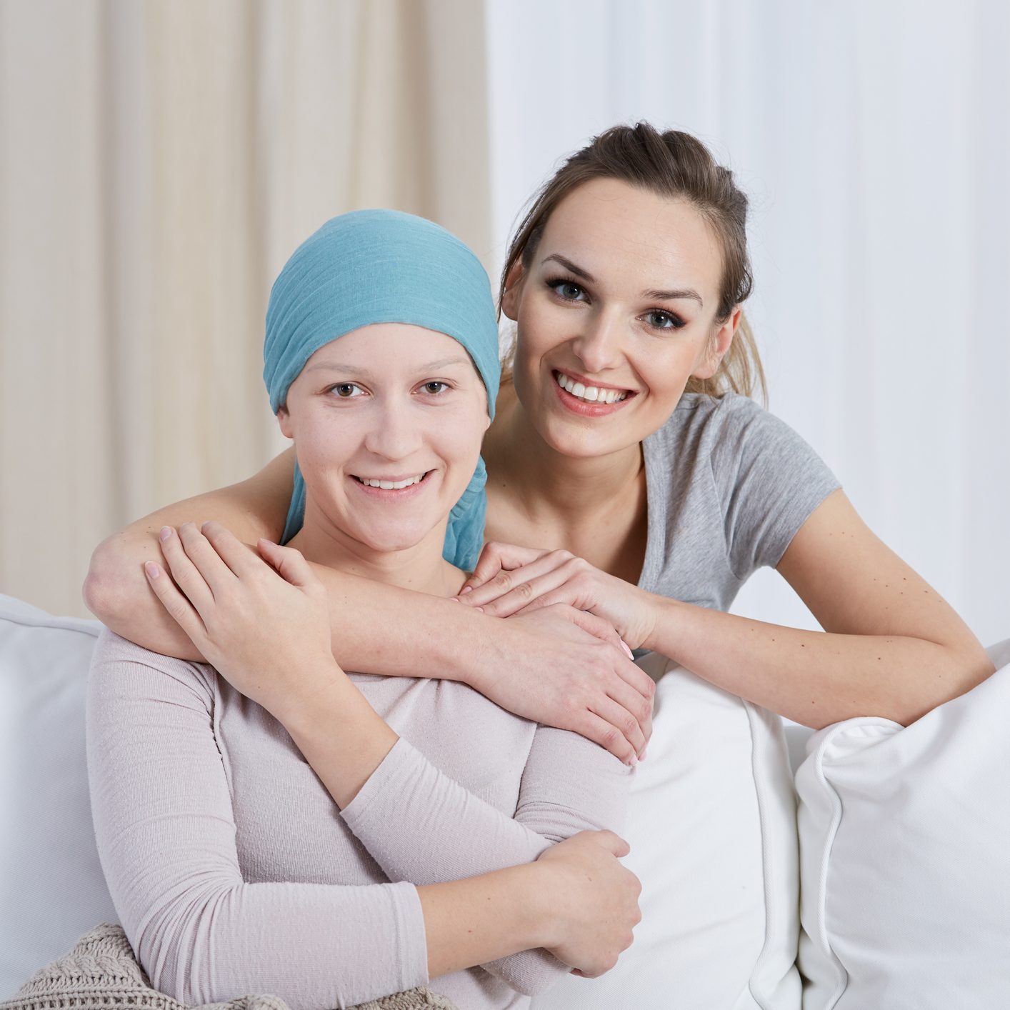 Smiling young woman hugging and supporting her ill sister